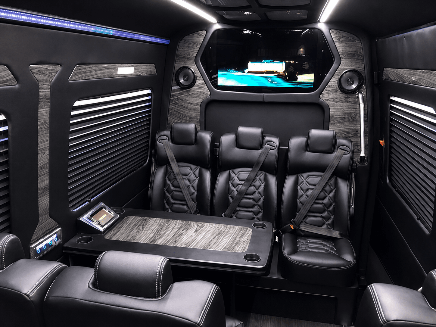 A luxury Miami Bus Company Sprinter van interior with premium leather seating and wood-trim paneling