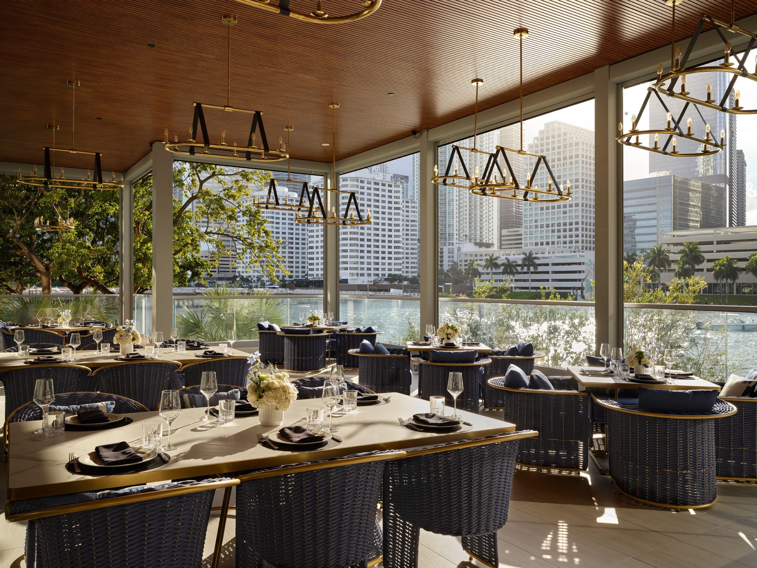 An upscale waterfront restaurant terrace overlooking the Miami skyline