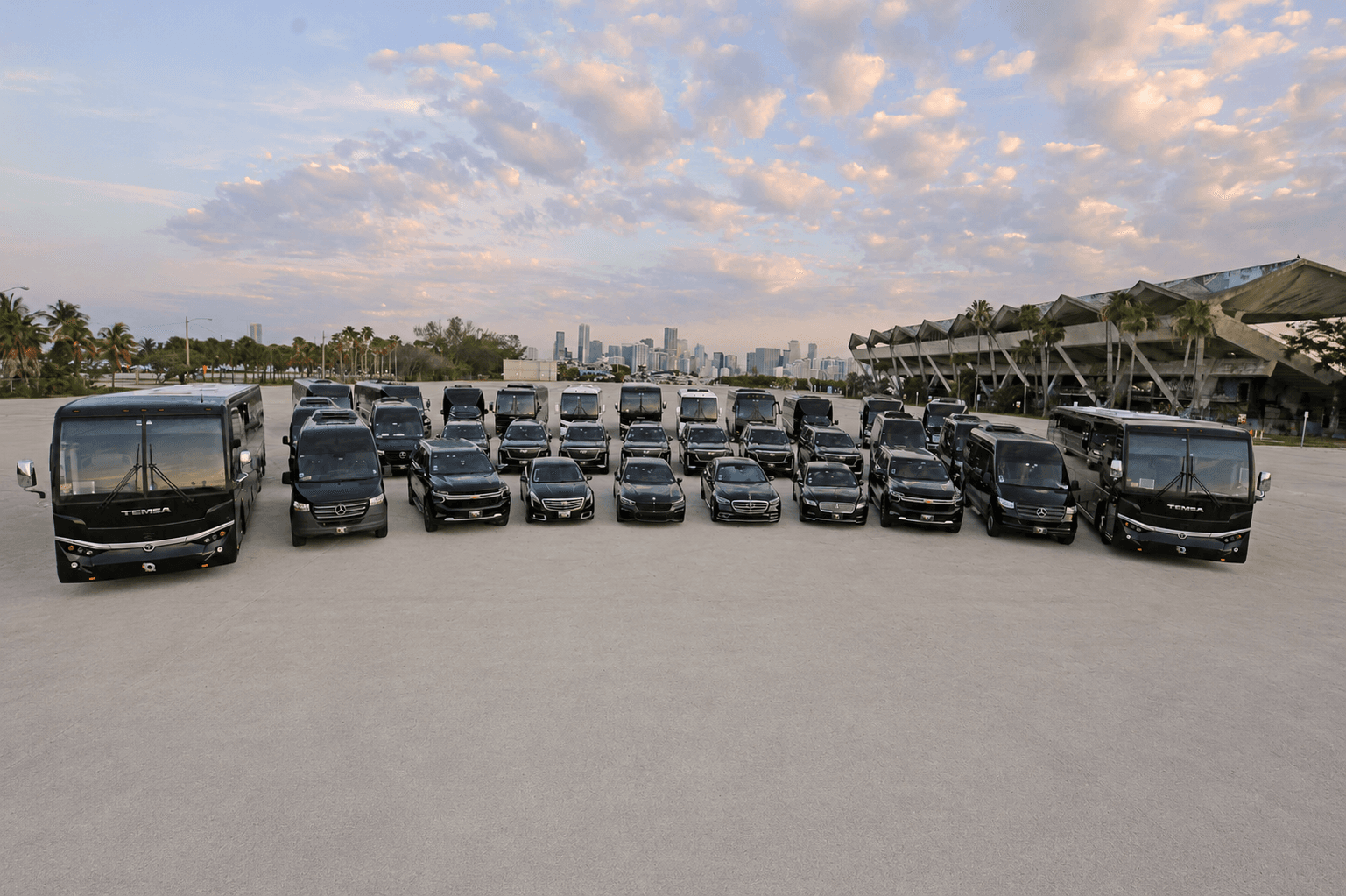 The full Miami Bus Company fleet of motorcoaches, mini coaches, Sprinter vans, and SUVs lined up on the Miami waterfront at dawn
