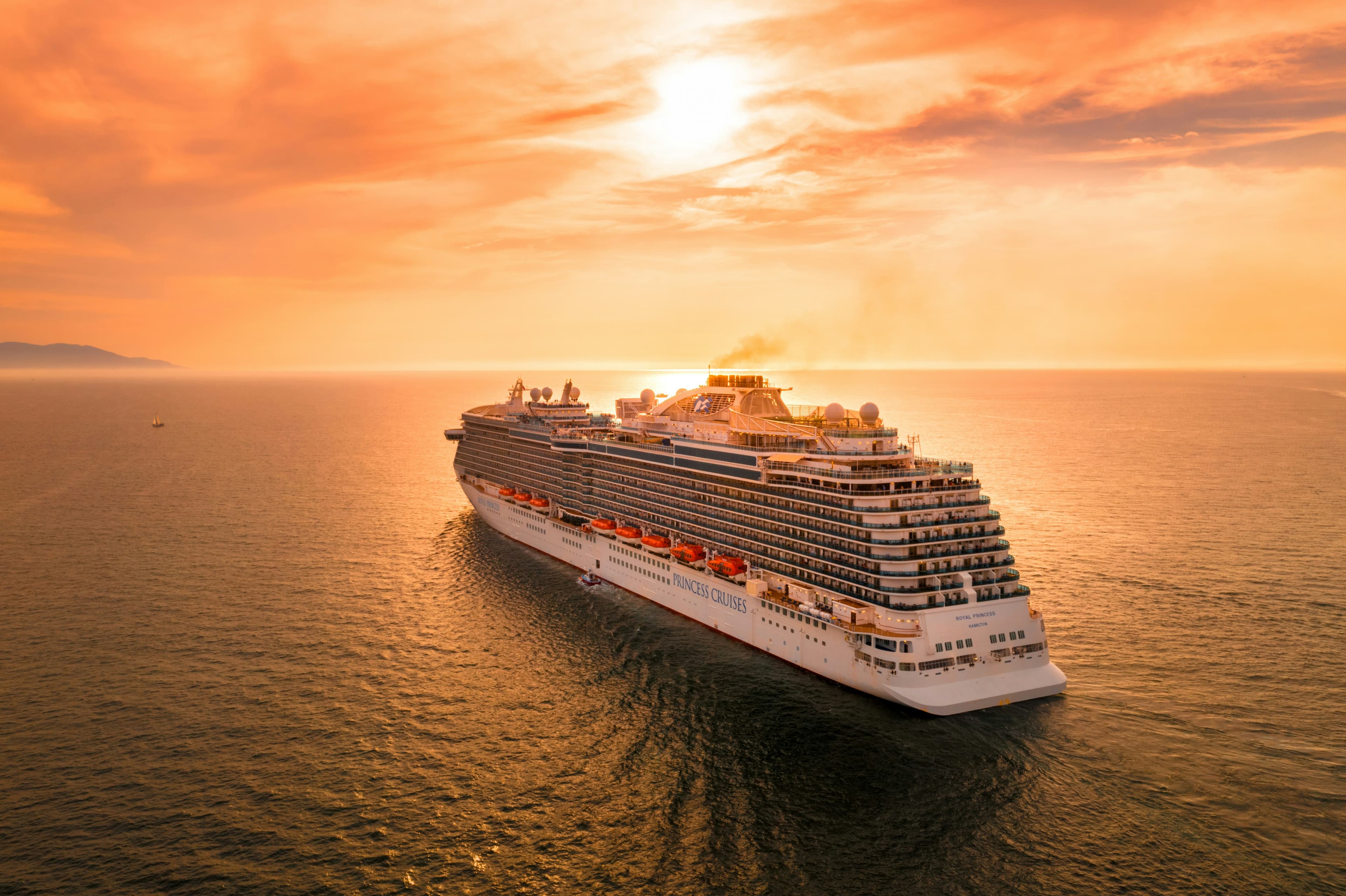 A cruise ship at sea during a golden sunset